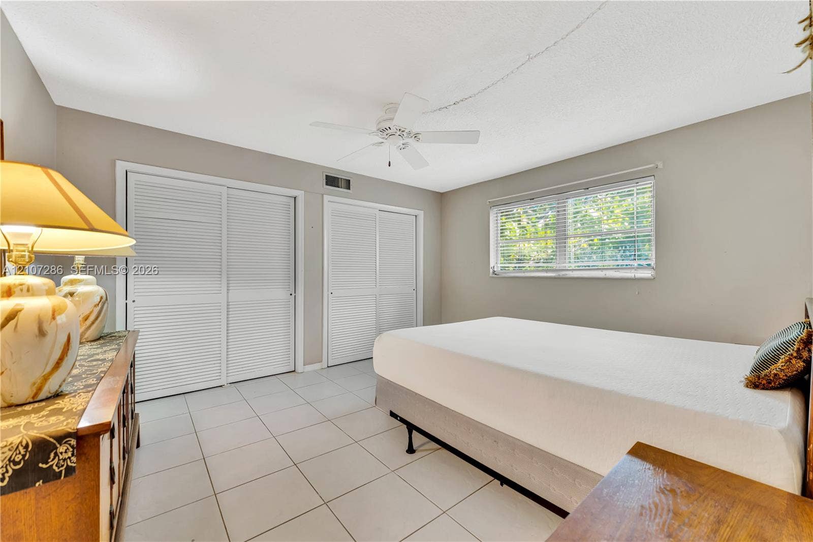 2458 Polk Street, #206, Hollywood, FL 33020 Ceramic tile flooring, dual louvered-style sliding closets, and a ceiling-mounted fan