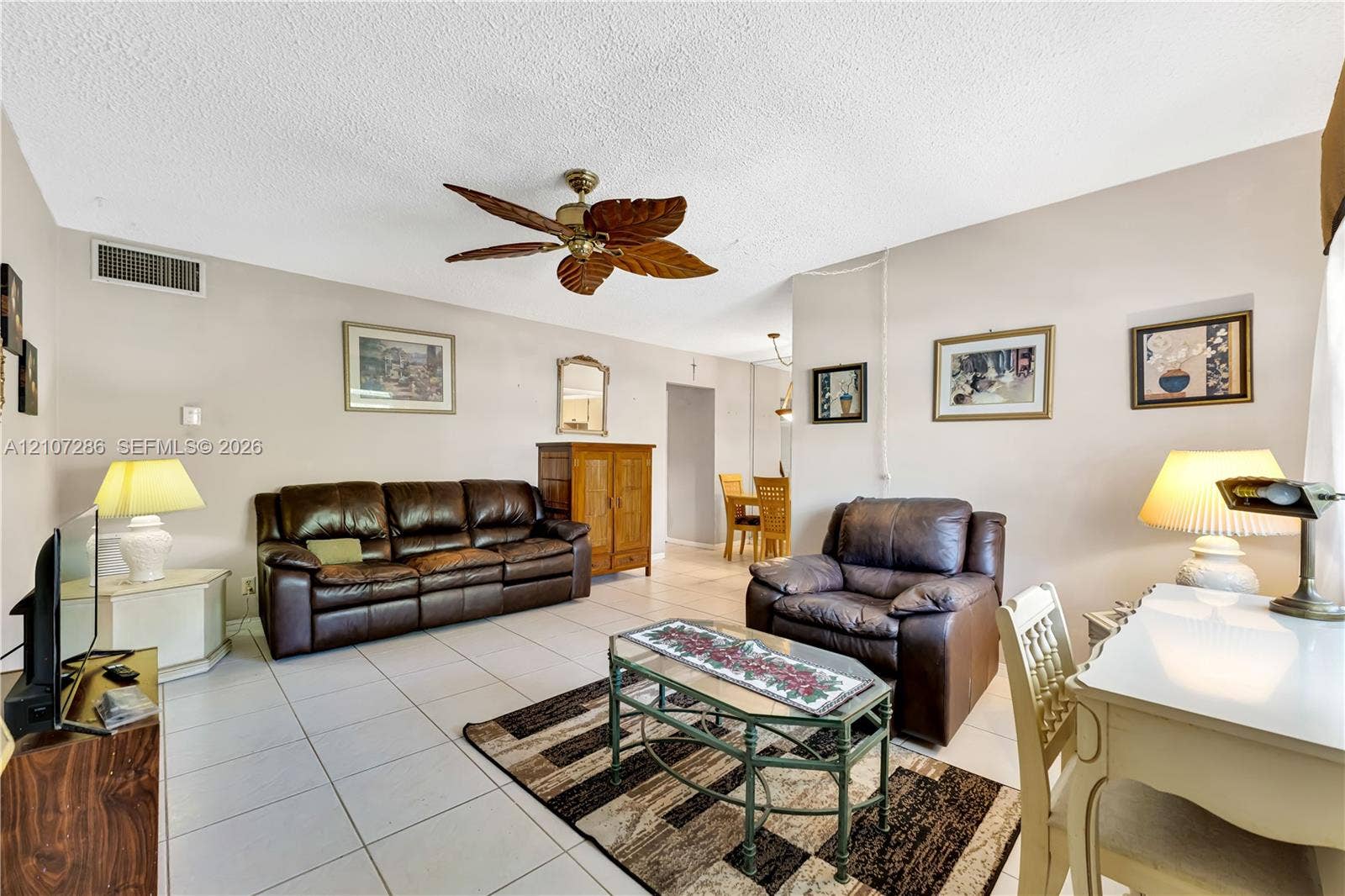2458 Polk Street, #206, Hollywood, FL 33020 Living space featuring neutral walls, white ceramic tile flooring, and a decorative ceiling fan with leaf-style blades