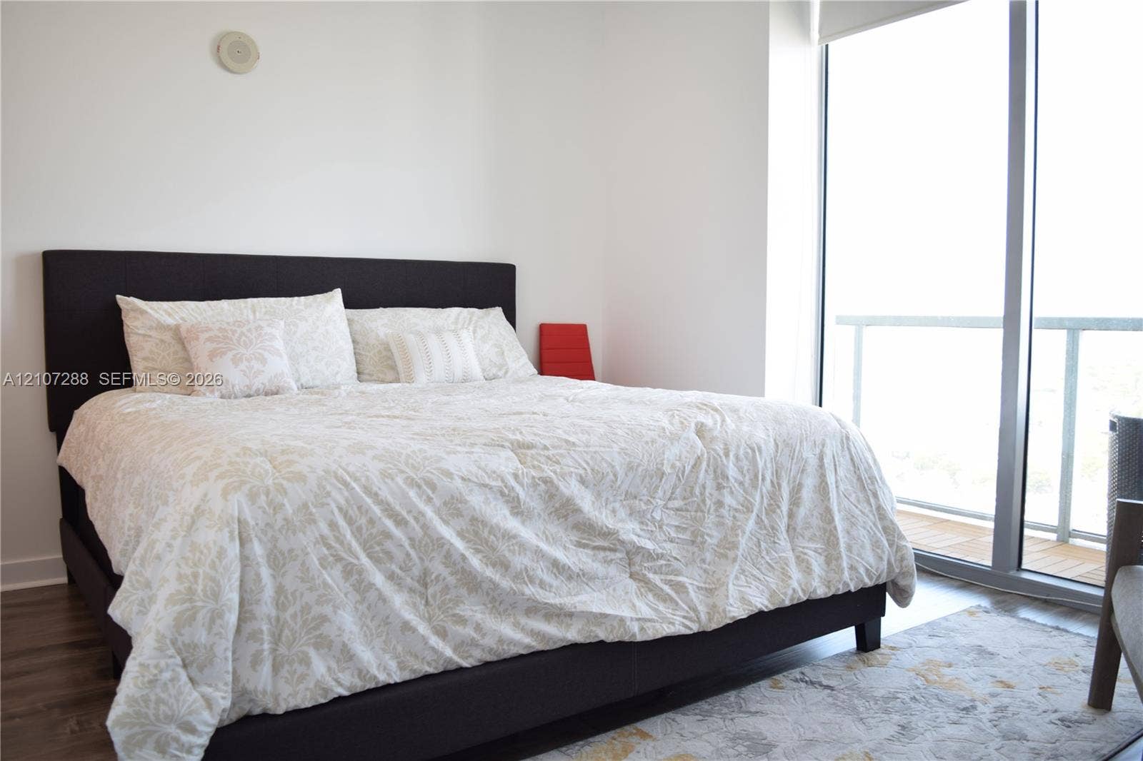 Floor-to-ceiling glass paneling with integrated door, wood-finish flooring, and minimalist white walls