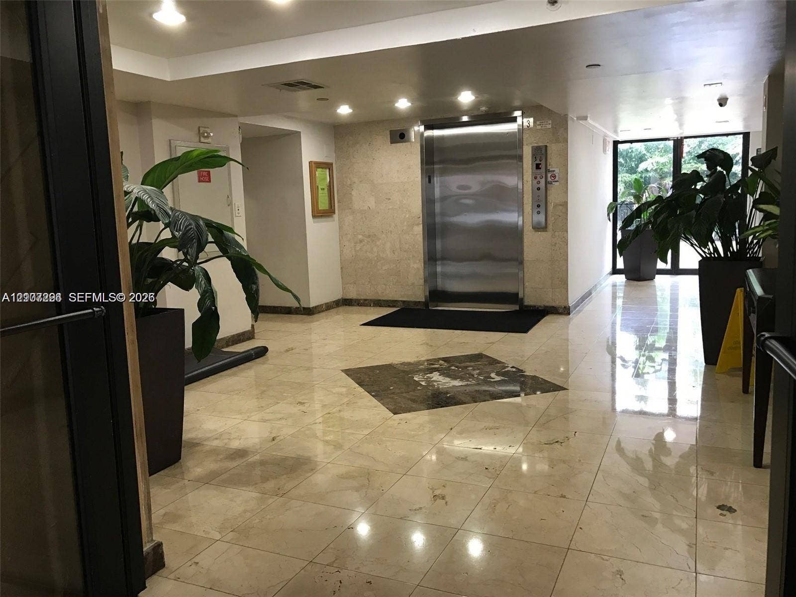 17021 N Bay Road, #219, Sunny Isles Beach, Sunny Isles Beach, FL 33160 Elevator lobby featuring polished stone flooring with an inlaid stone medallion, recessed lighting, and a stainless steel elevator door