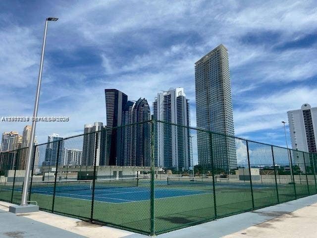 17021 N Bay Road, #219, Sunny Isles Beach, Sunny Isles Beach, FL 33160 Hard-surfaced tennis court enclosed by chain-link fencing, featuring overhead pole lighting