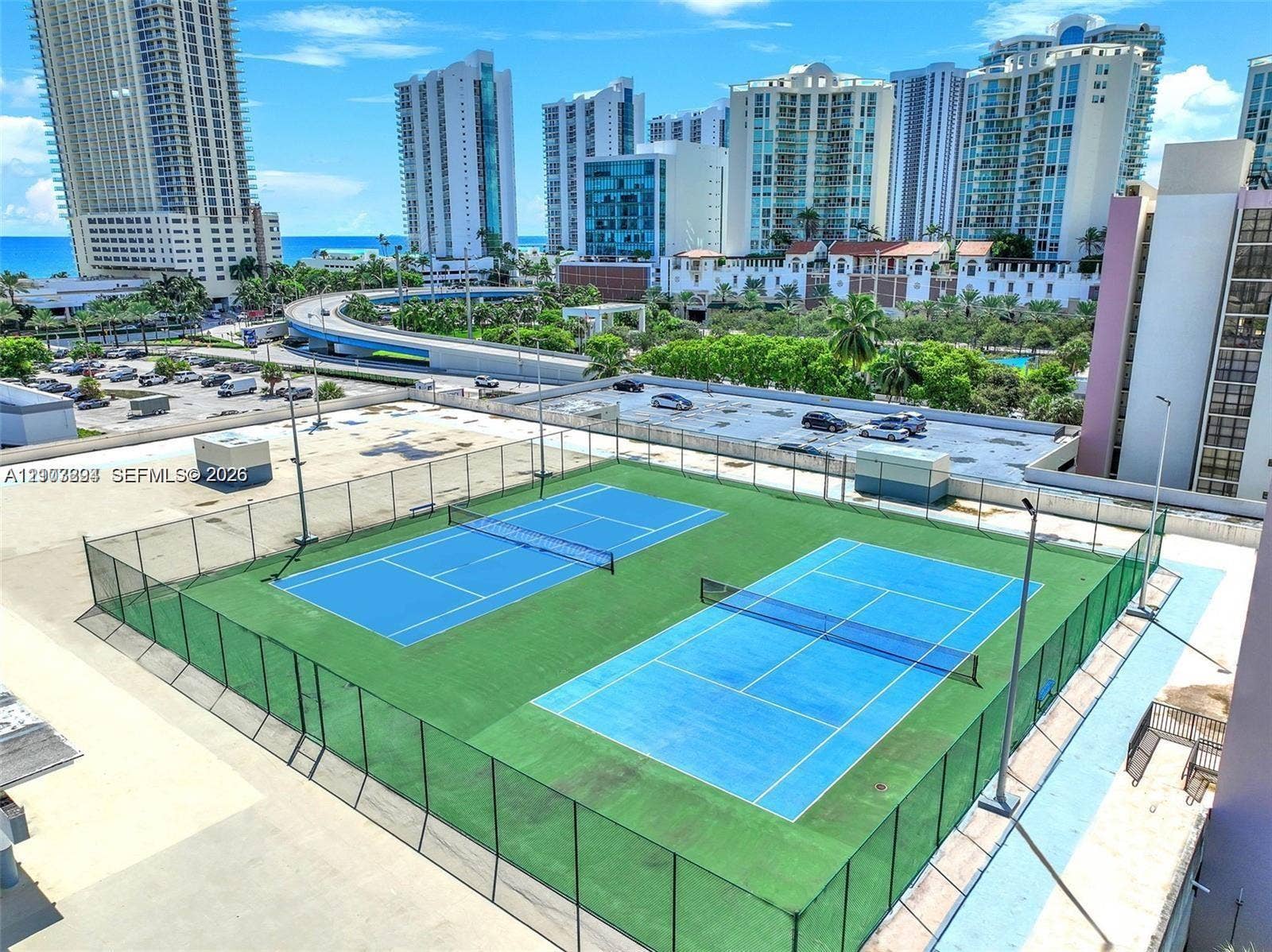 17021 N Bay Road, #219, Sunny Isles Beach, Sunny Isles Beach, FL 33160 Dual tennis courts with perimeter fencing and elevated high-mast lighting