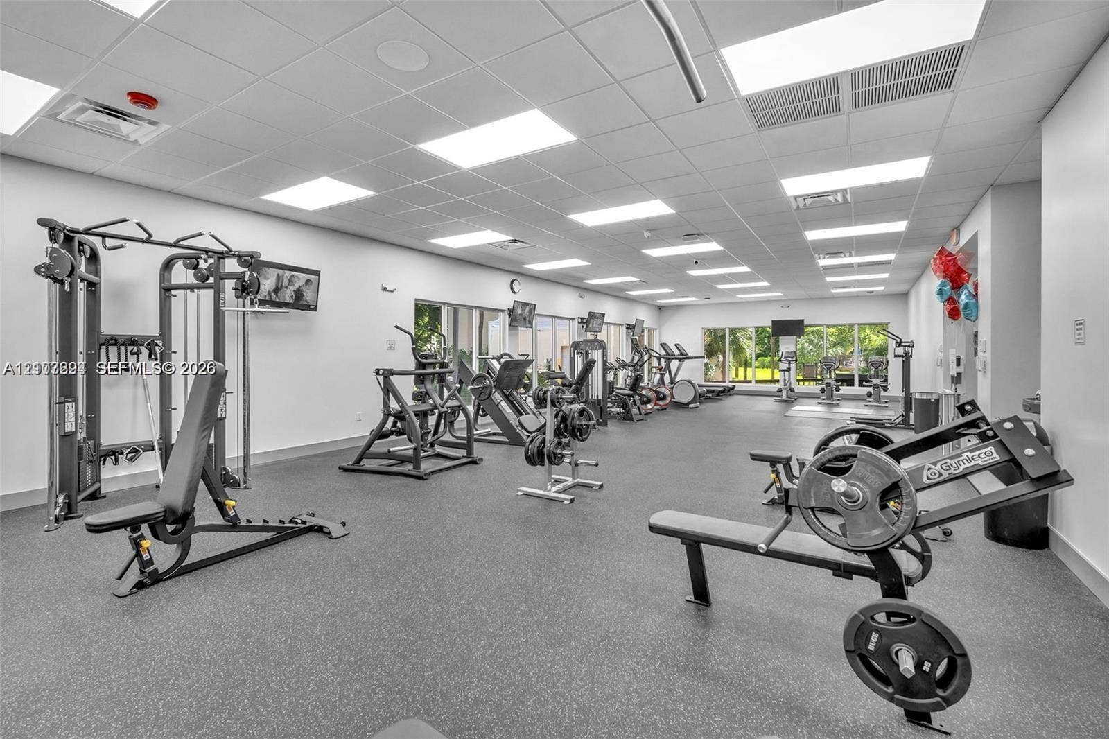 17021 N Bay Road, #219, Sunny Isles Beach, Sunny Isles Beach, FL 33160 Fitness center featuring recessed drop-ceiling lighting, resilient rubberized flooring, and expansive windows