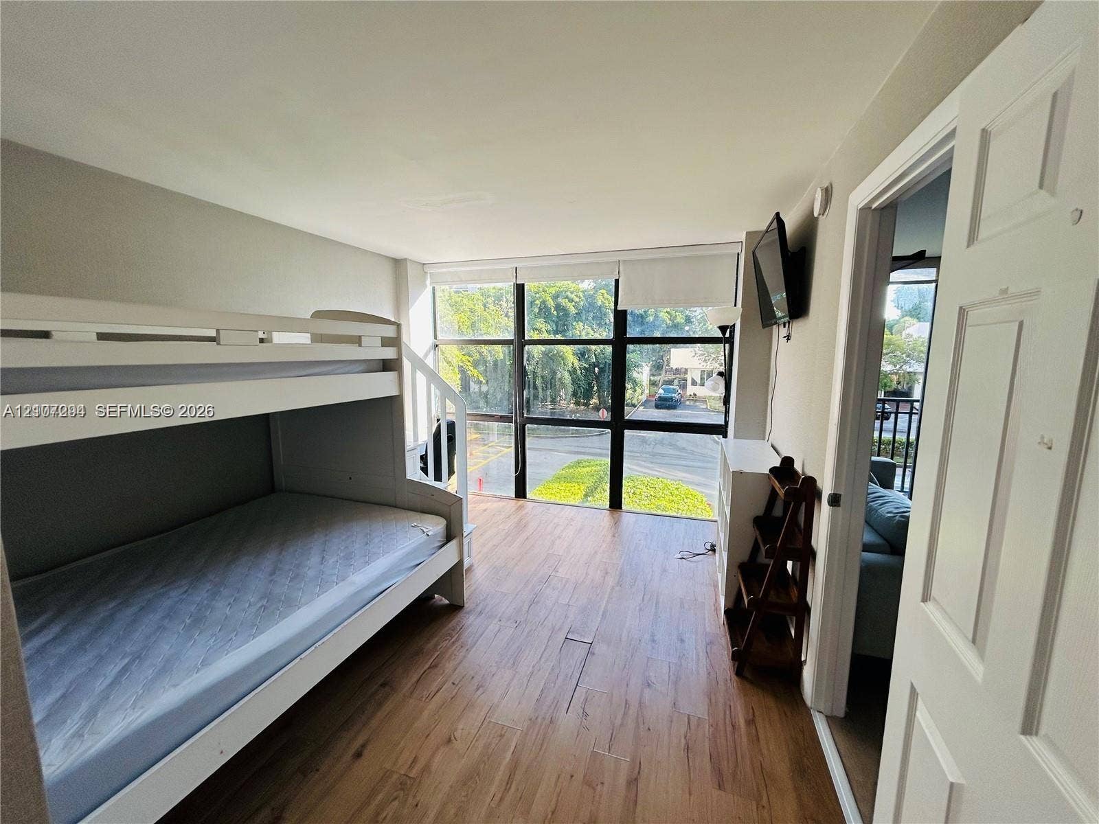 17021 N Bay Road, #219, Sunny Isles Beach, Sunny Isles Beach, FL 33160 Floor-to-ceiling windows with black metal framing, wood-finish flooring, and white paneled interior door