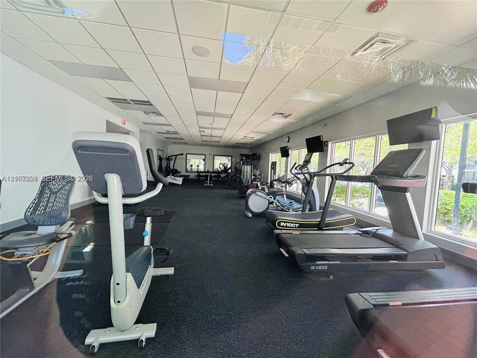 17021 N Bay Road, #219, Sunny Isles Beach, Sunny Isles Beach, FL 33160 Fitness room featuring high-impact rubber flooring, drop ceiling with recessed lighting, and large windows