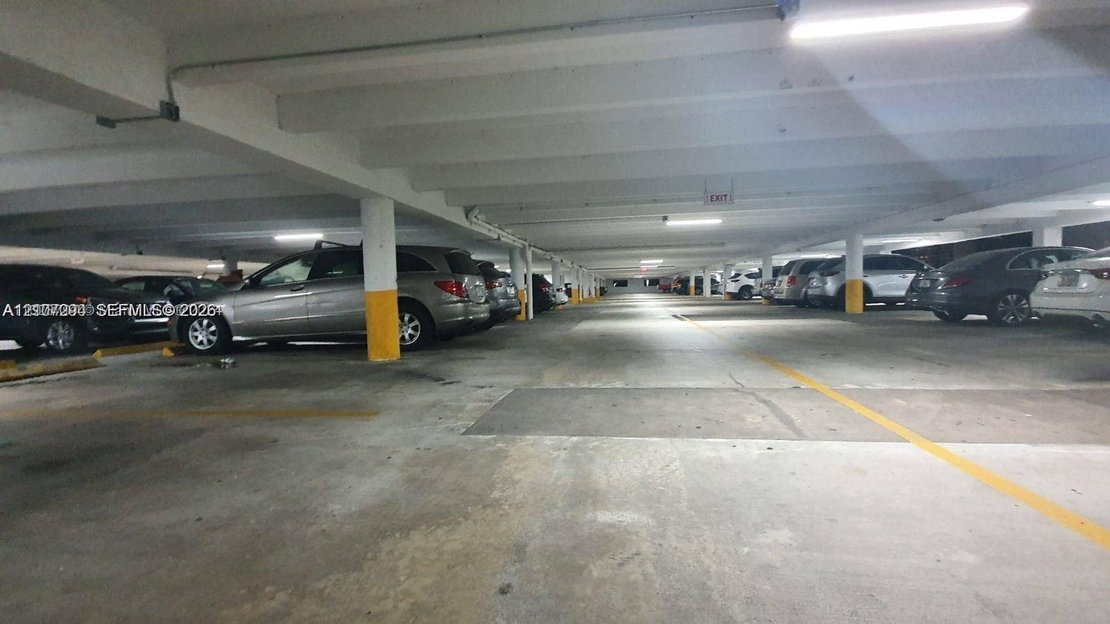 17021 N Bay Road, #219, Sunny Isles Beach, Sunny Isles Beach, FL 33160 Covered parking garage featuring concrete flooring, structural support columns, and overhead lighting