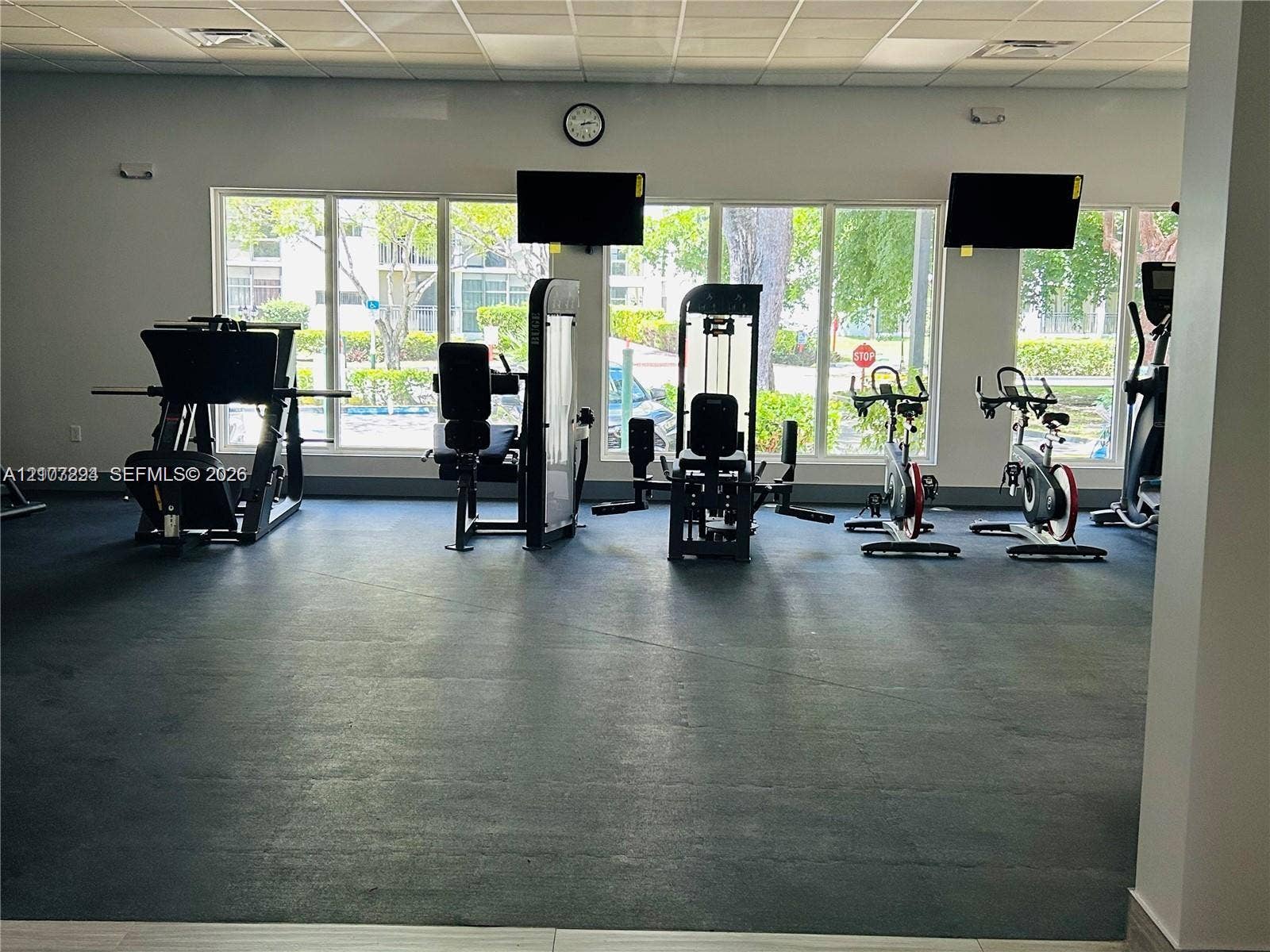 17021 N Bay Road, #219, Sunny Isles Beach, Sunny Isles Beach, FL 33160 Fitness center featuring durable rubber flooring, a drop-tile ceiling, and oversized windows providing natural lighting