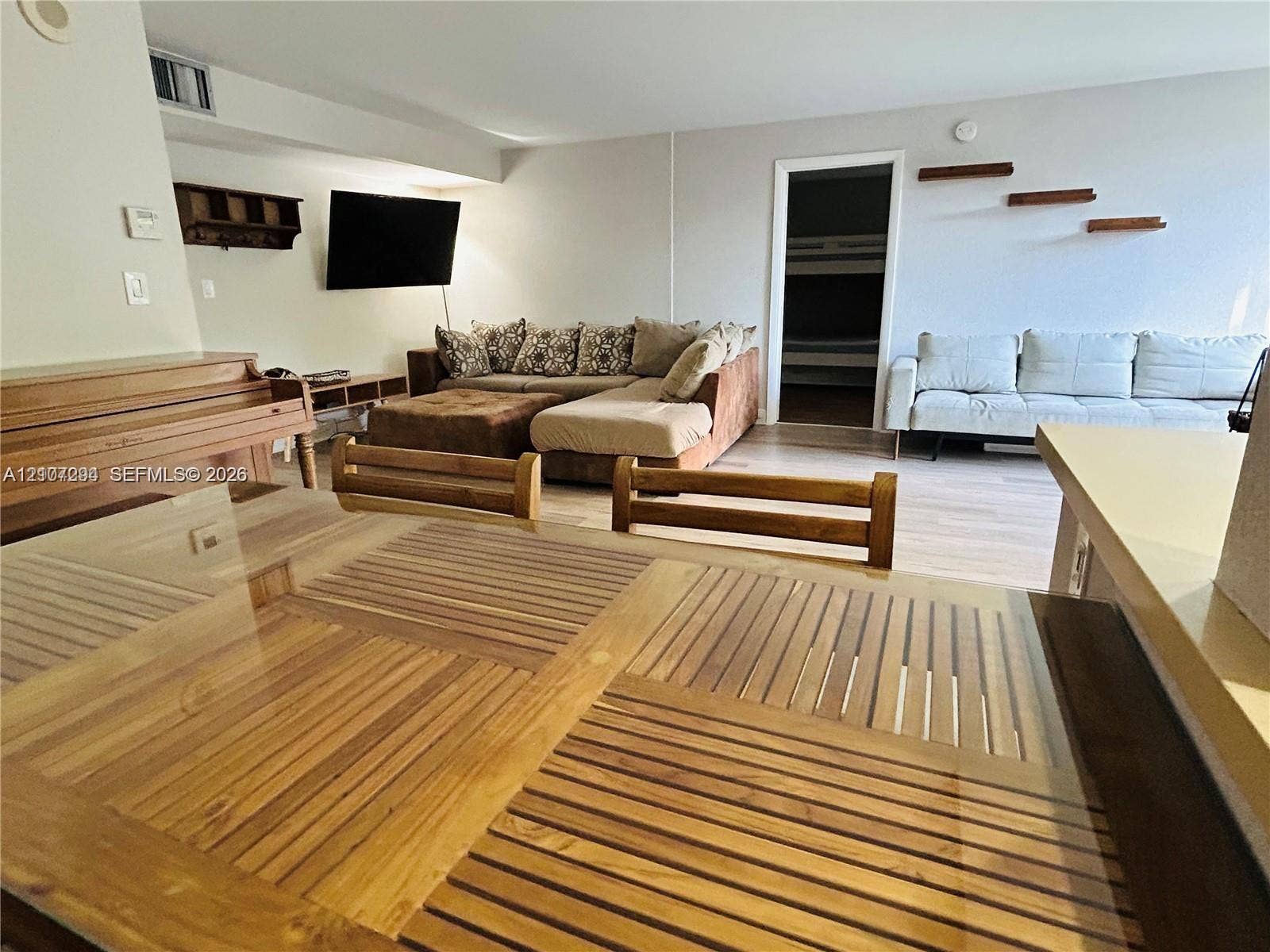 17021 N Bay Road, #219, Sunny Isles Beach, Sunny Isles Beach, FL 33160 Open living area featuring wood-finish flooring, built-in wall shelving, and neutral wall tones