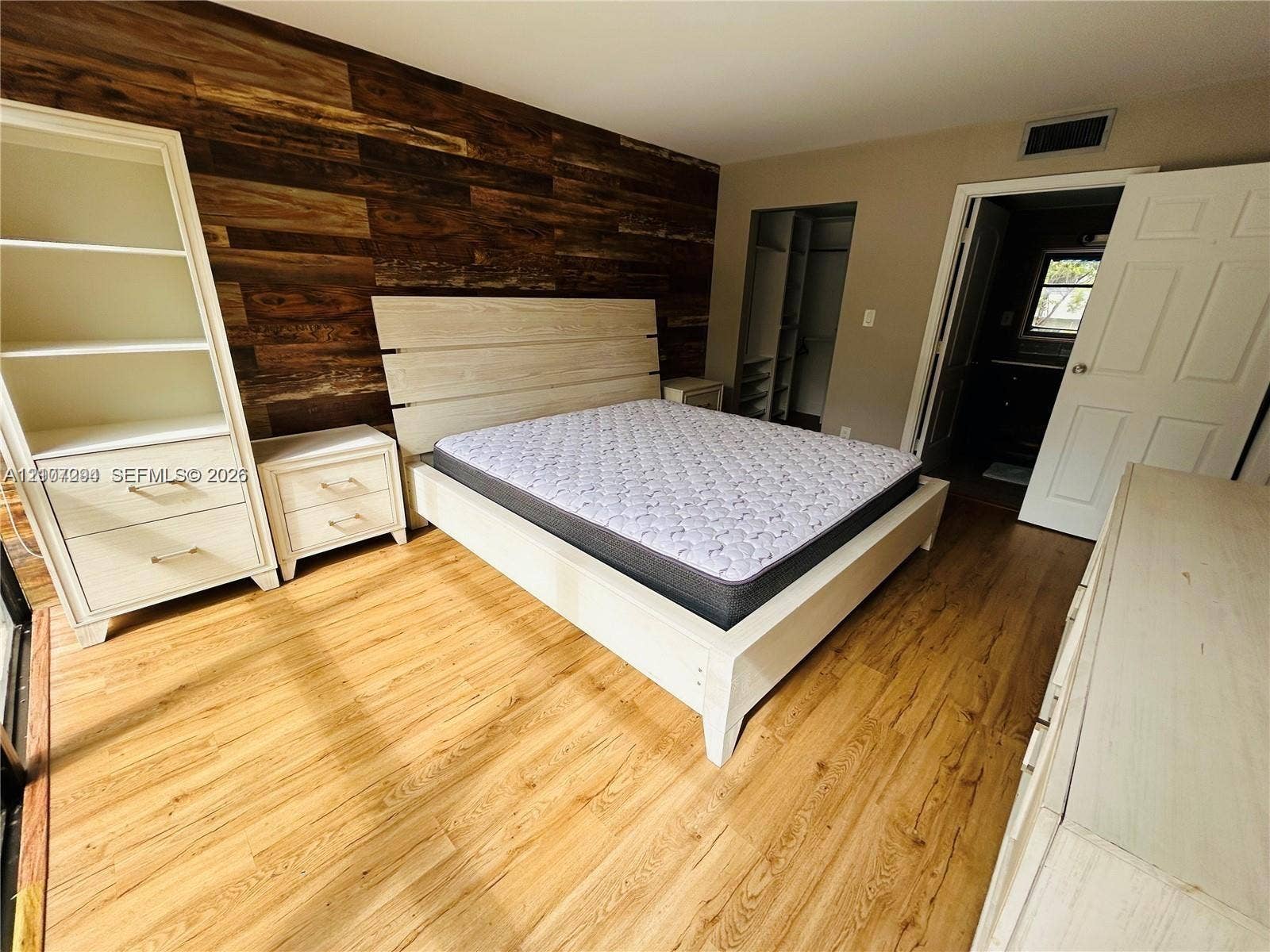 17021 N Bay Road, #219, Sunny Isles Beach, Sunny Isles Beach, FL 33160 Accent wall featuring horizontal wood paneling, wood-finish flooring, and built-in shelving unit