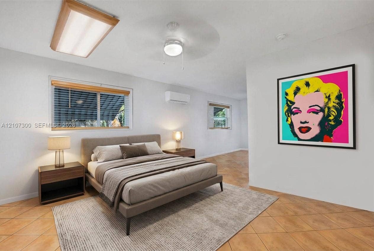 2051 NE 68th Street, Fort Lauderdale, FL 33308 Ceramic tile flooring, wall-mounted ductless heating and cooling unit, dual-pane windows with wooden blinds, flush-mount fluorescent lighting, and a ceiling fan with integrated light fixture