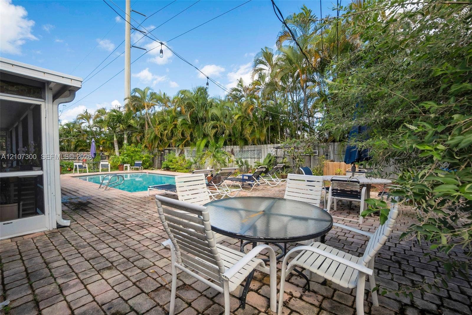 2051 NE 68th Street, Fort Lauderdale, FL 33308 Outdoor space featuring a brick-paved patio, in-ground swimming pool, and privacy fencing
