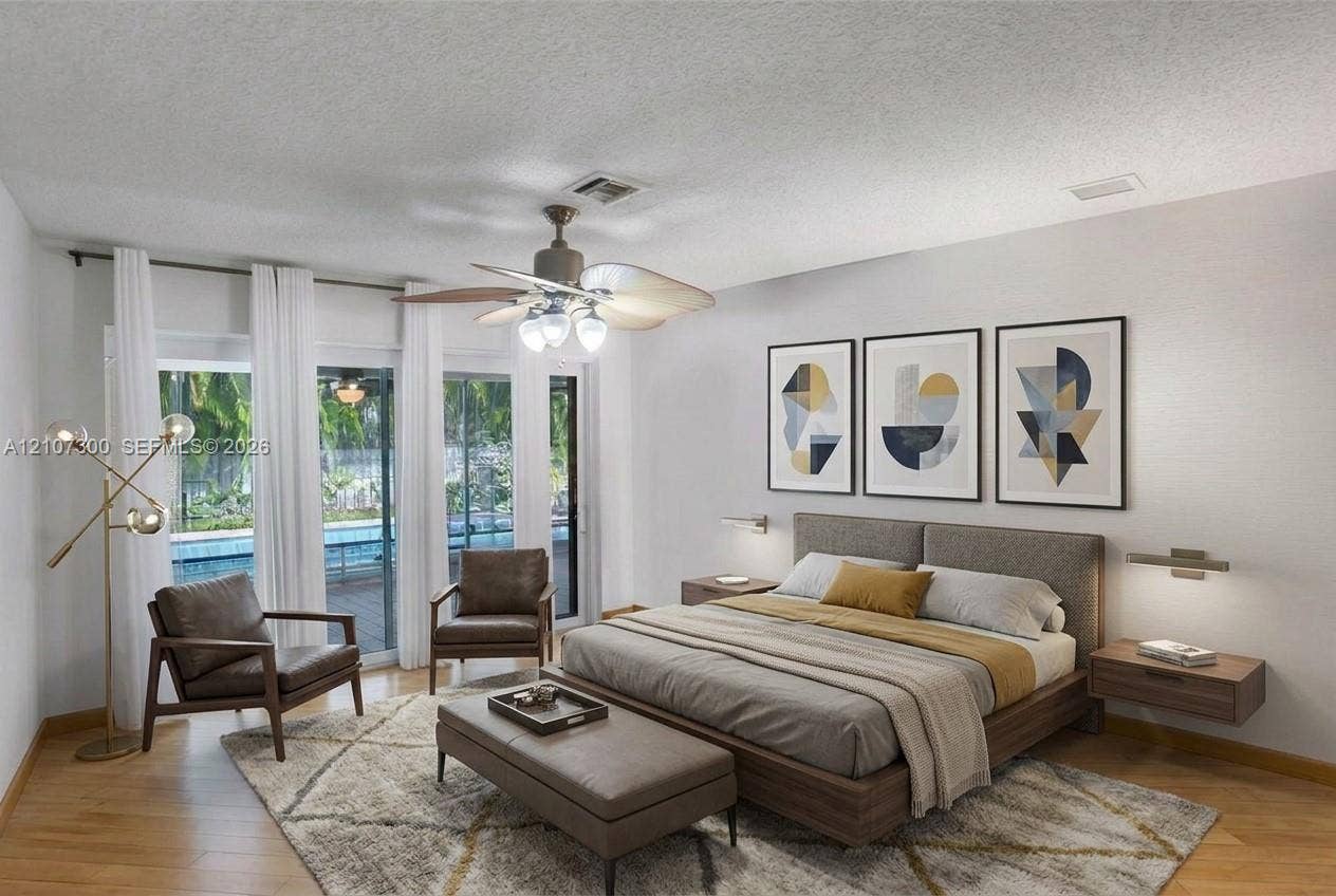2051 NE 68th Street, Fort Lauderdale, FL 33308 Wood-finish flooring, sliding glass doors, ceiling fan with integrated lighting, and wall-mounted light fixtures