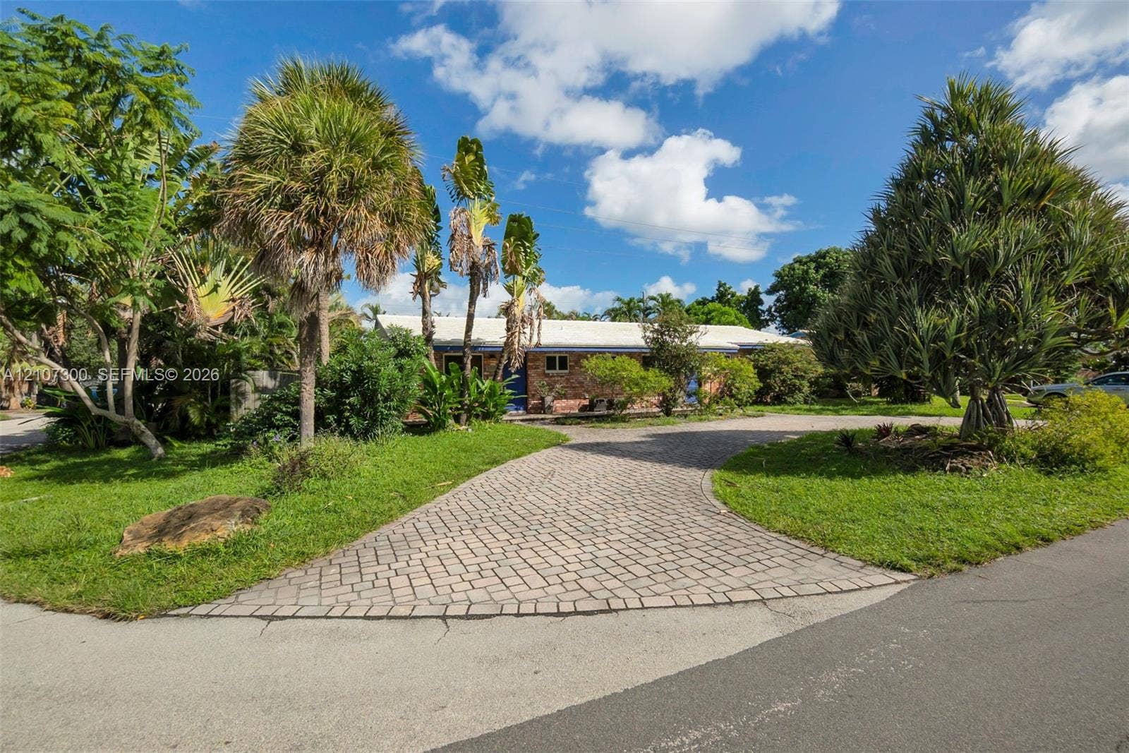 2051 NE 68th Street, Fort Lauderdale, FL 33308 Brick exterior, paver driveway, and mature landscaping