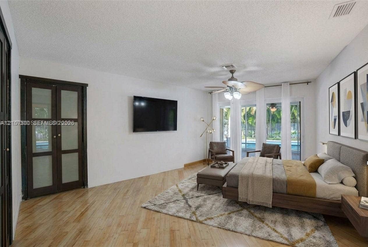 2051 NE 68th Street, Fort Lauderdale, FL 33308 Wood-finish flooring, ceiling fan with integrated lighting, and glass-paneled closet doors