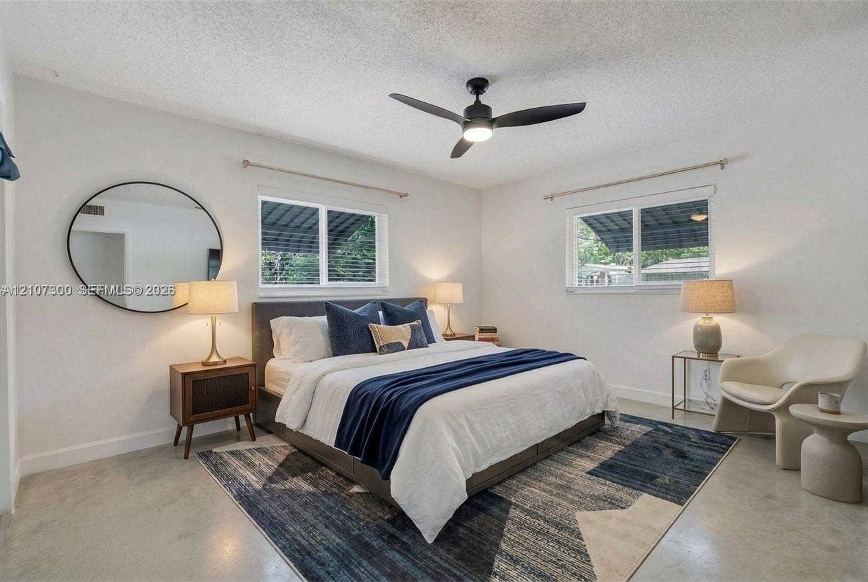 2051 NE 68th Street, Fort Lauderdale, FL 33308 Interior space featuring concrete flooring, dual horizontal sliding windows, and a matte black ceiling fan with an integrated light fixture