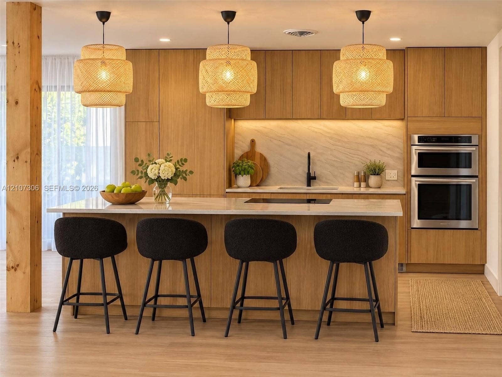 4322 Alton Road, Miami Beach, FL 33140 Kitchen featuring flat-panel wood cabinetry, integrated double wall ovens, a large island with stone-finish countertop, textured pendant lighting, and light-tone wood-finish flooring