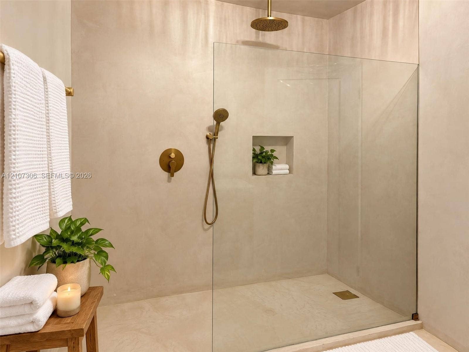 4322 Alton Road, Miami Beach, FL 33140 Walk-in shower featuring a seamless glass enclosure, monochromatic wall finish, brass-tone rain showerhead, matching hand-held sprayer, and a built-in recessed niche