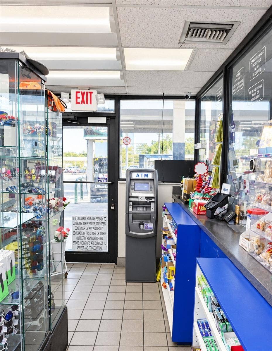 Commercial space featuring tile flooring, floor-to-ceiling glass paneling, built-in service counter, and overhead fluorescent lighting