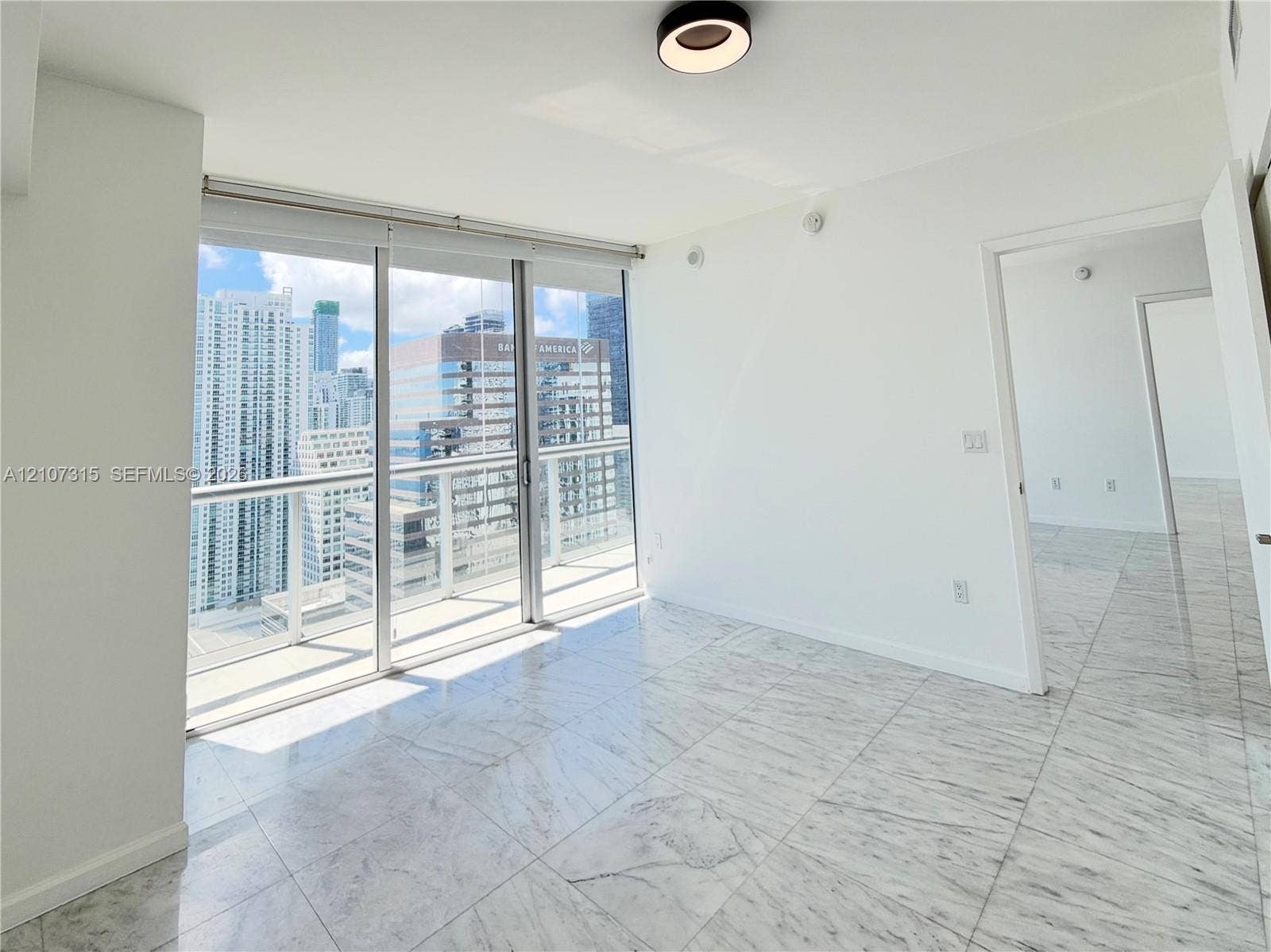 495 Brickell Avenue, #3803, Miami, FL 33131 Floor-to-ceiling sliding glass doors, private balcony with metal railing, polished stone-finish flooring, and recessed circular LED lighting