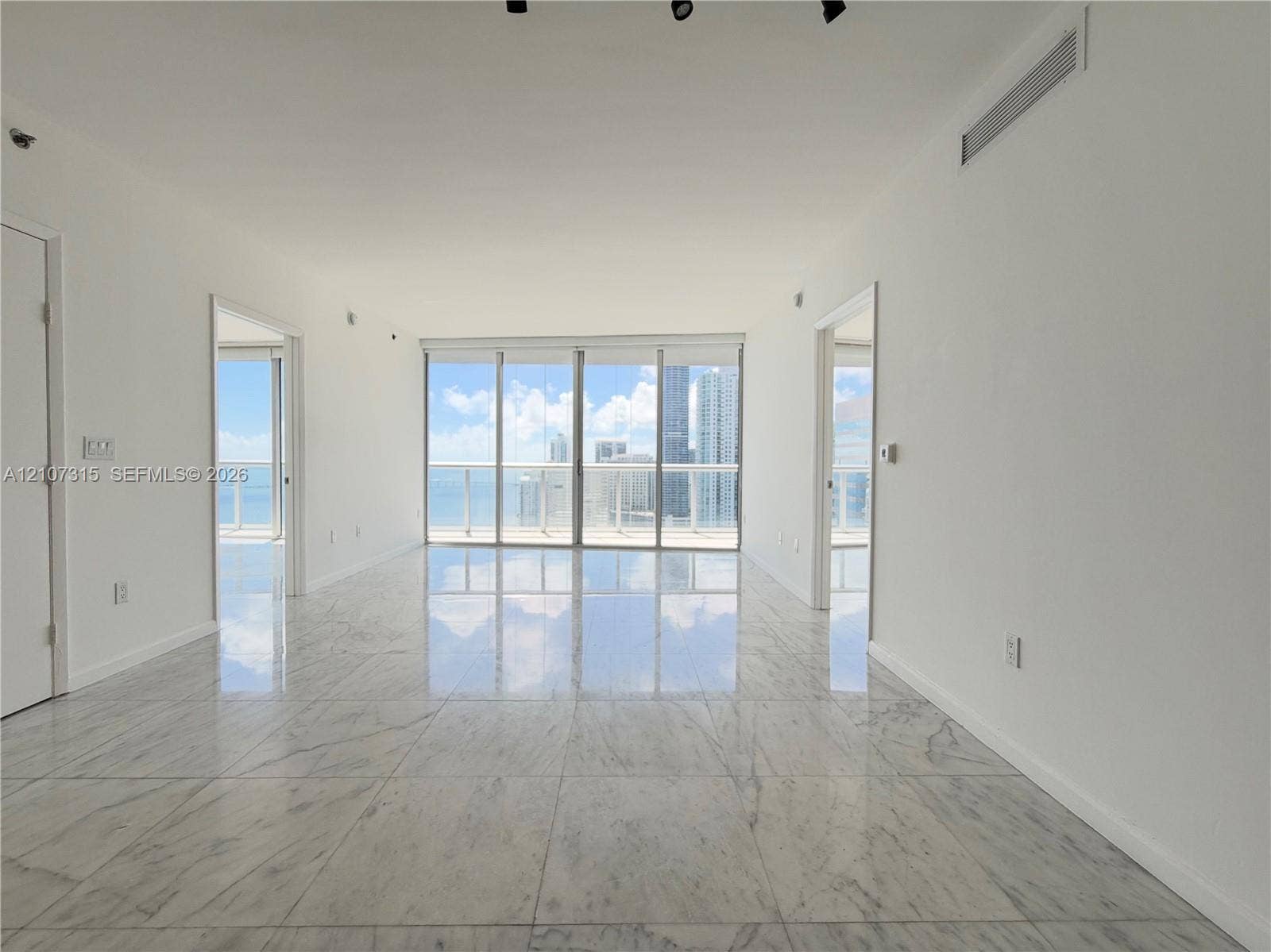 495 Brickell Avenue, #3803, Miami, FL 33131 Polished stone flooring, floor-to-ceiling glass wall, and glass-panel balcony railing