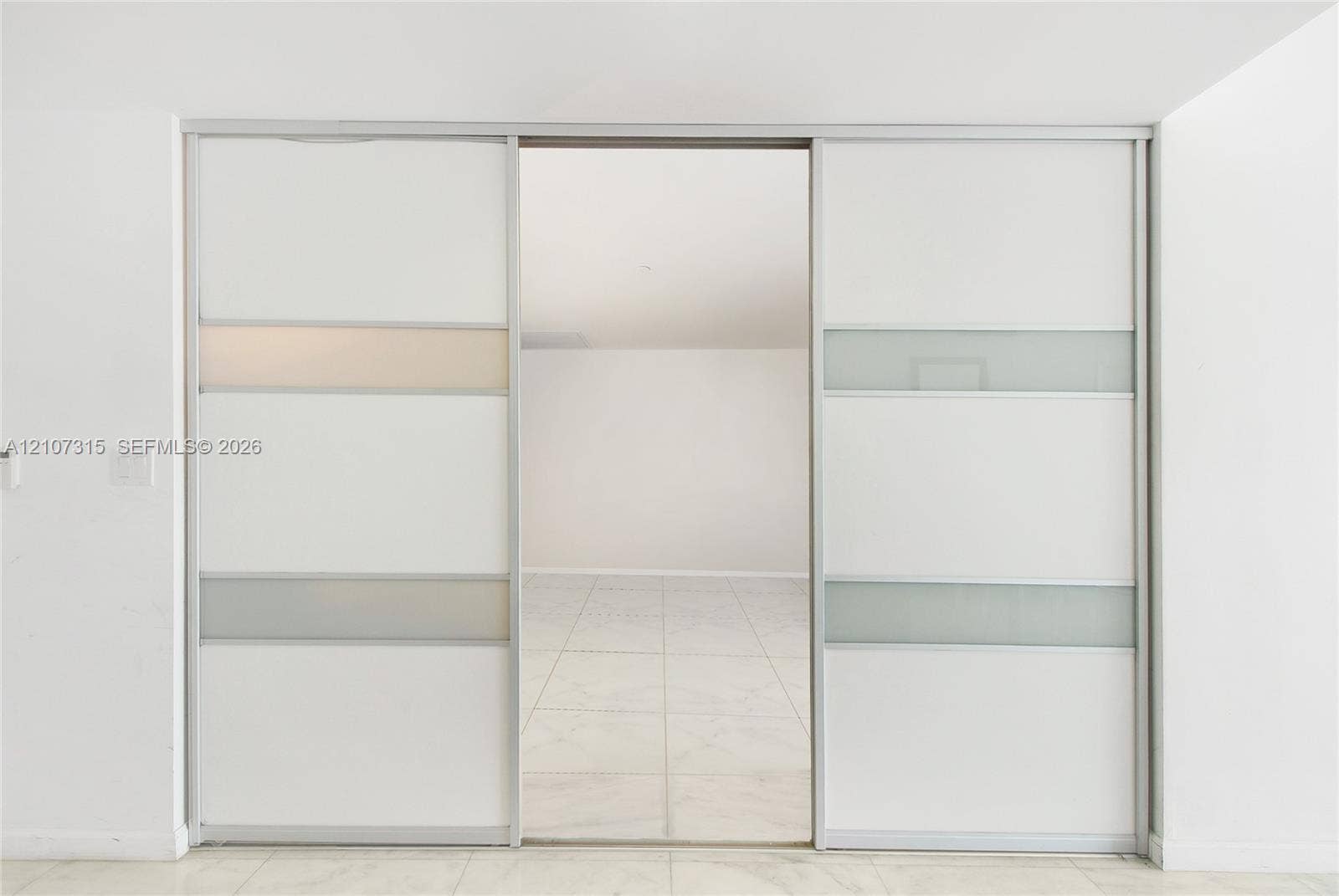 495 Brickell Avenue, #3803, Miami, FL 33131 Sliding floor-to-ceiling panels featuring white composite finishes and translucent glass inserts, set within a polished metal track system