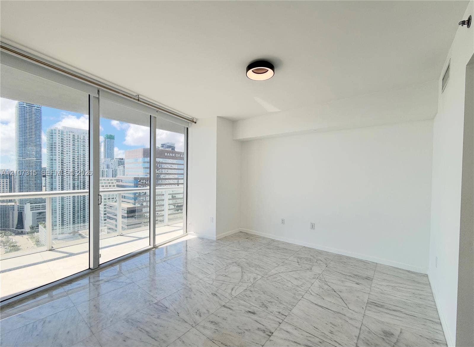 495 Brickell Avenue, #3803, Miami, FL 33131 Floor-to-ceiling sliding glass doors, stone-finish tile flooring, recessed LED flush-mount lighting, and private balcony with railing