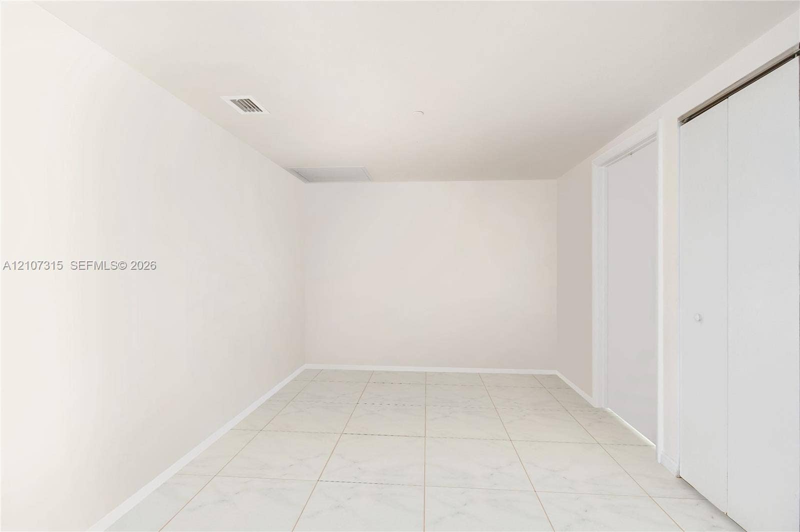 495 Brickell Avenue, #3803, Miami, FL 33131 Neutral-toned interior space featuring light-colored tile flooring and dual-panel closet doors