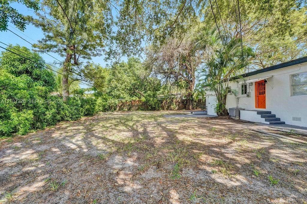 1801 NE 154th Street, #0, North Miami Beach, North Miami Beach, FL 33162 Expansive backyard featuring mature trees, established landscaping, and a concrete patio