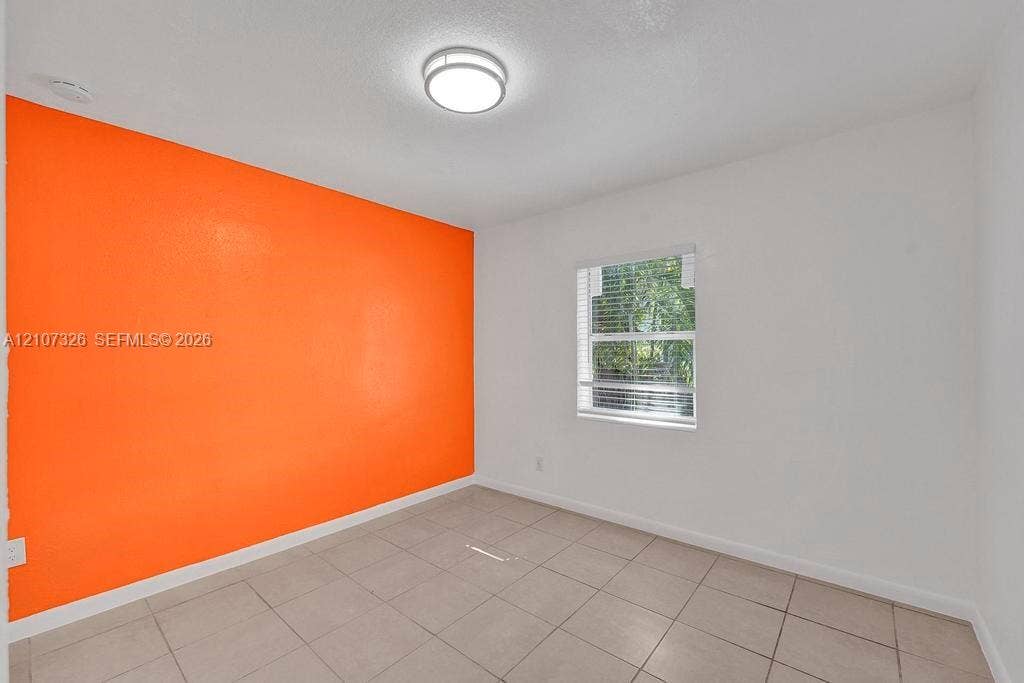 1801 NE 154th Street, #0, North Miami Beach, North Miami Beach, FL 33162 Room featuring tile flooring, a single-pane window with horizontal blinds, and a flush-mount overhead light fixture