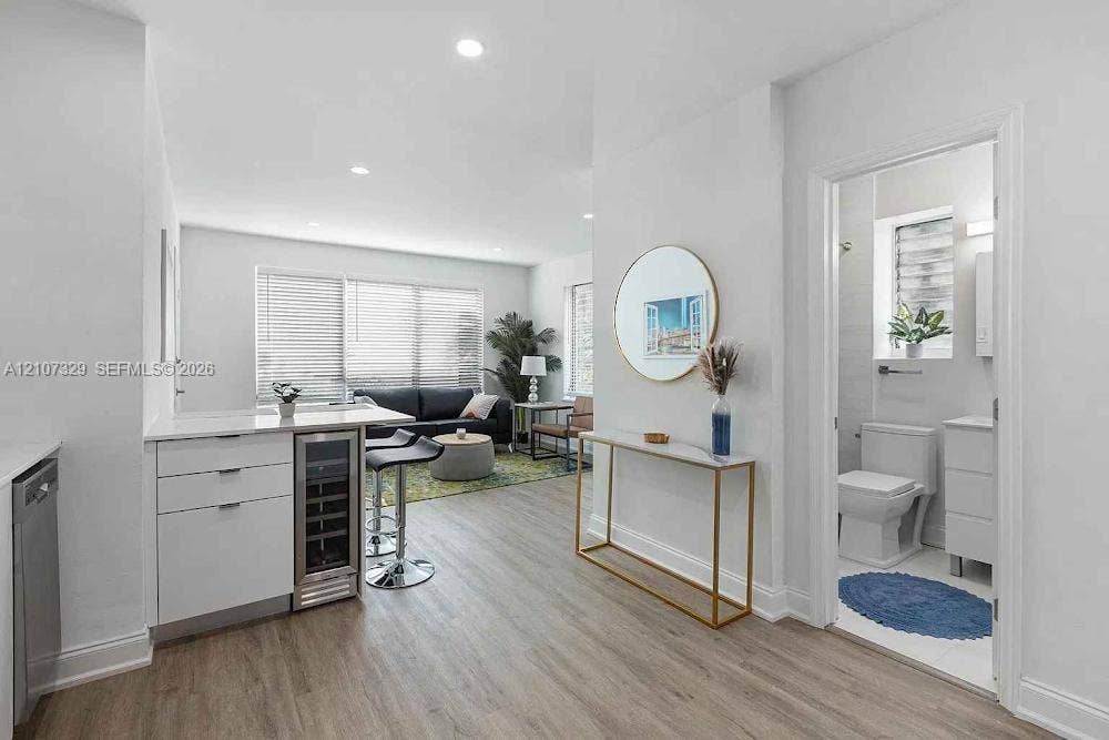 830 9th Street, #14, Miami Beach, Miami Beach, FL 33139 Kitchen featuring a white peninsula with an integrated beverage cooler, recessed lighting, and wood-finish flooring throughout