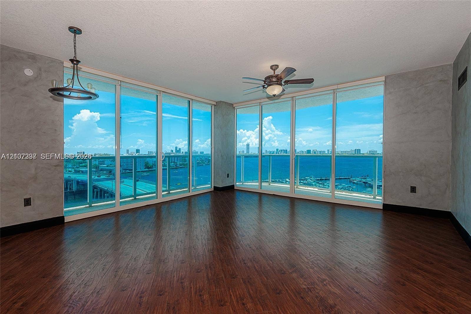 1881 79th St Causeway, #1007, North Bay Village, FL 33141 Floor-to-ceiling windows, wood-finish flooring, textured wall treatments, ceiling-mounted light fixture, and integrated ceiling fan
