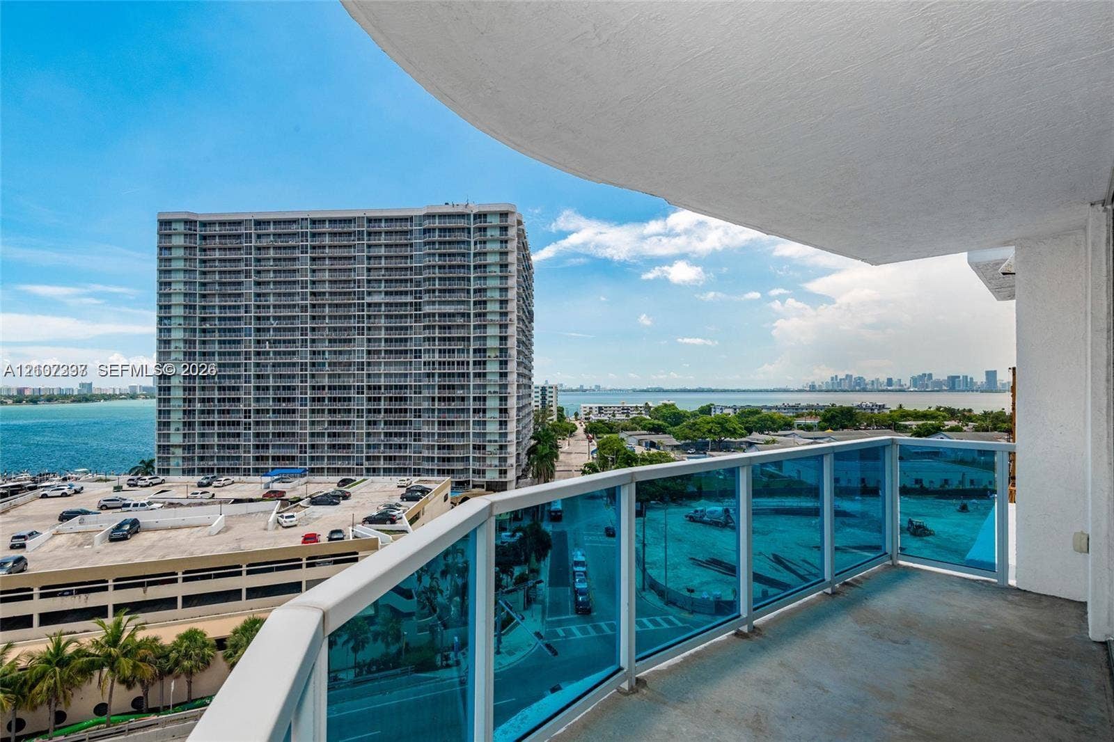 1881 79th St Causeway, #1007, North Bay Village, FL 33141 Covered balcony featuring blue-tinted glass railings and concrete flooring