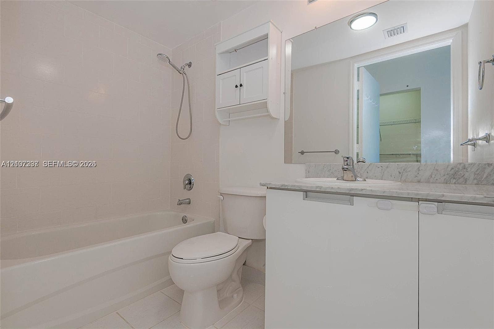 1881 79th St Causeway, #1007, North Bay Village, FL 33141 Bathroom featuring a vanity with stone-finish countertop, undermount sink, built-in storage cabinet, full-width mirror, and a tub-shower combination