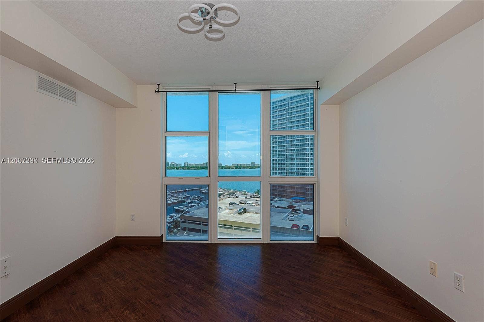 1881 79th St Causeway, #1007, North Bay Village, FL 33141 Floor-to-ceiling windows, wood-finish flooring, and modern multi-ring ceiling lighting