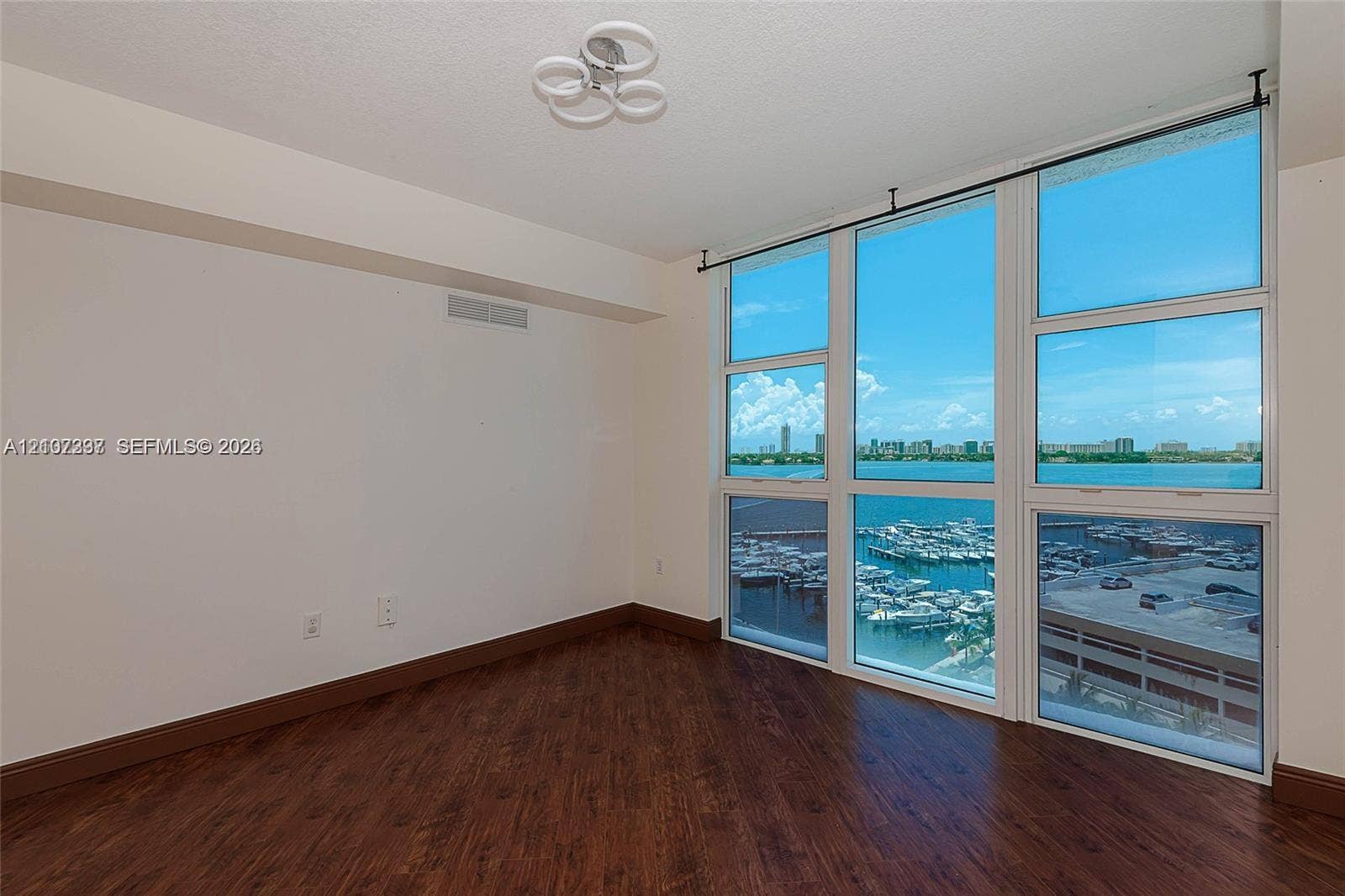 1881 79th St Causeway, #1007, North Bay Village, FL 33141 Floor-to-ceiling windows, wood-finish flooring, and modern multi-ring flush mount lighting