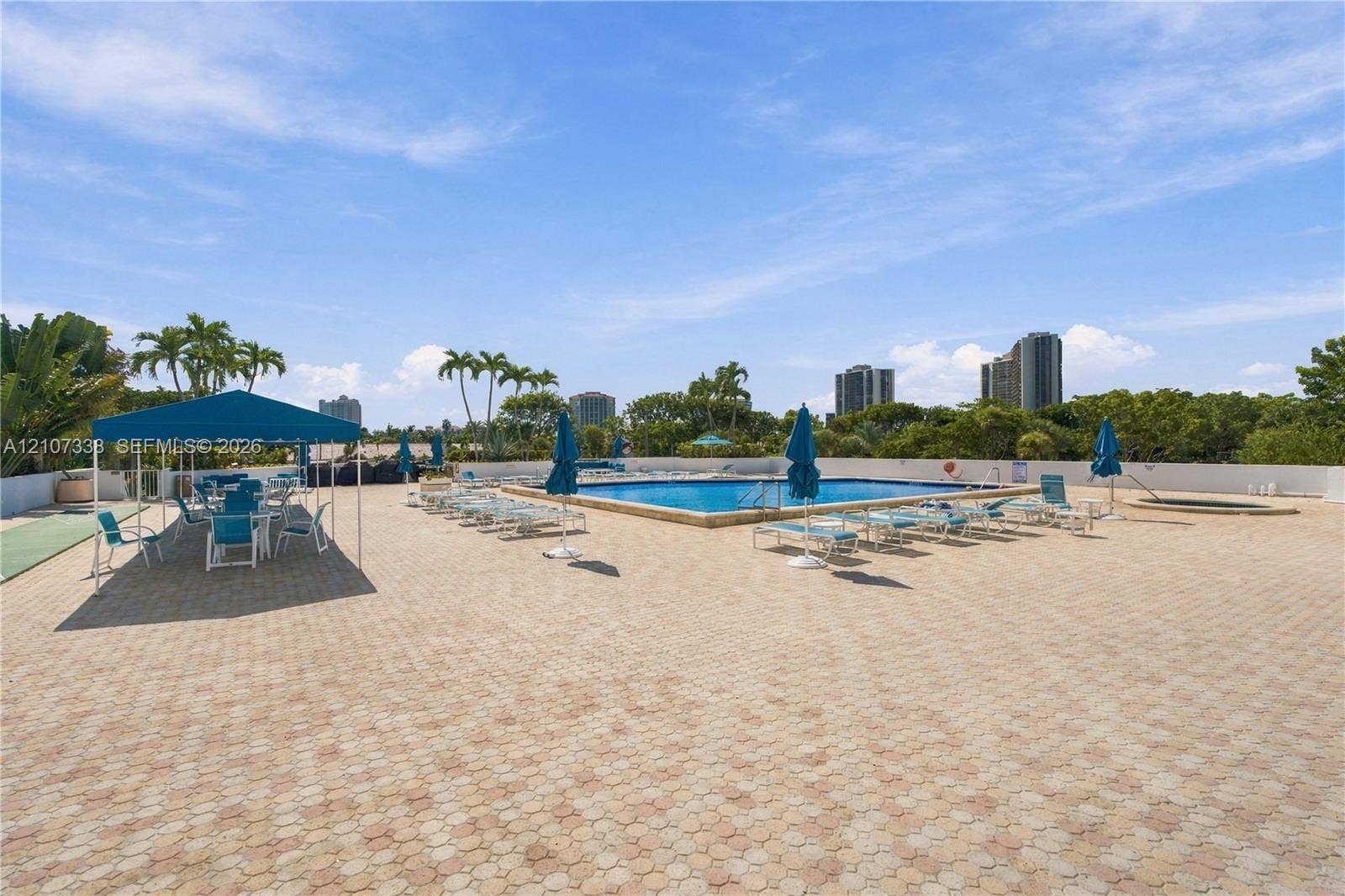20355 NE 34th Court, #1824, Aventura, FL 33180 Rooftop pool deck with stone paver surfacing, rectangular swimming pool, integrated spa, and permanent metal-frame canopy structure