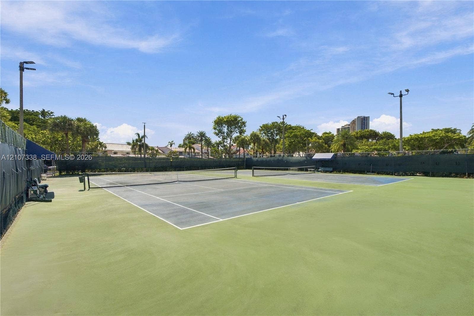 20355 NE 34th Court, #1824, Aventura, FL 33180 Dual hard-surface tennis courts featuring perimeter fencing, integrated court lighting, and netted boundaries