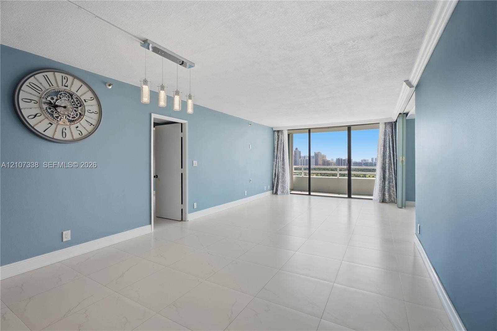 20355 NE 34th Court, #1824, Aventura, FL 33180 Open-concept living space featuring large-format tile flooring, floor-to-ceiling glass sliding doors, private balcony, and multi-light linear pendant fixture