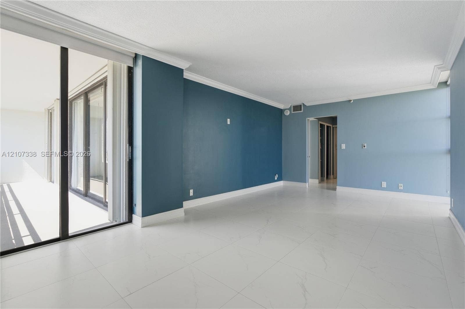 20355 NE 34th Court, #1824, Aventura, FL 33180 Large living area featuring polished tile flooring, floor-to-ceiling sliding glass doors, crown molding, and neutral wall tones
