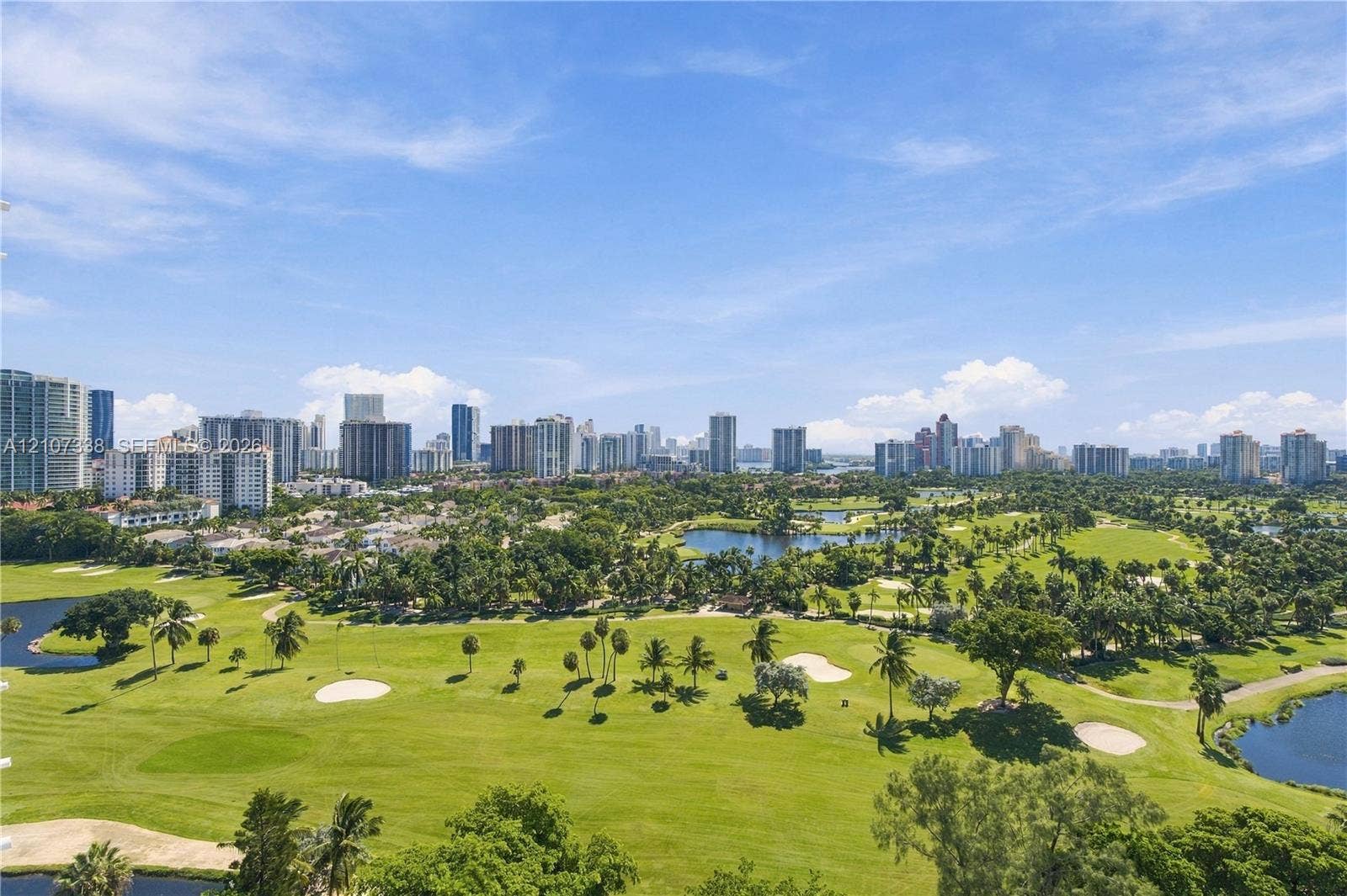 20355 NE 34th Court, #1824, Aventura, FL 33180 Elevated perspective featuring expansive golf course fairways, scattered mature palms, multiple water hazards, and a panoramic city skyline backdrop