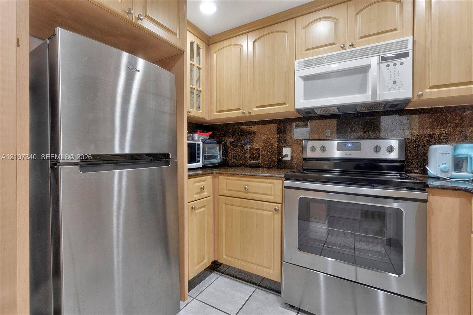 3401 N Country Club Drive, #406, Aventura, Aventura, FL 33180 Kitchen featuring light wood cabinetry, stone countertops, stainless steel refrigerator, integrated microwave, and stainless steel electric range