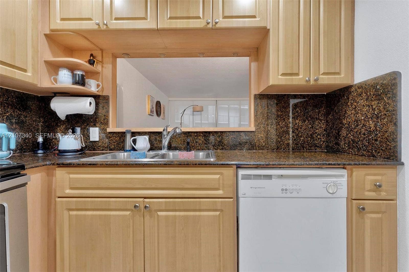 3401 N Country Club Drive, #406, Aventura, Aventura, FL 33180 Kitchen featuring natural-finish wood cabinetry, stone-surface countertops, matching stone backsplash, dual-basin stainless steel sink with metal faucet, and built-in dishwasher