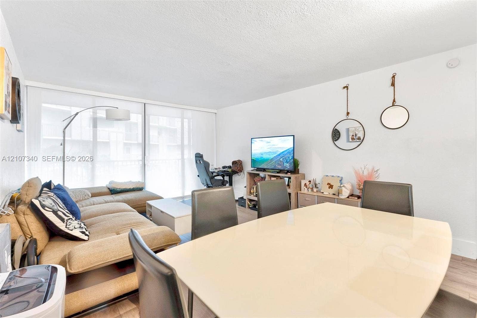 3401 N Country Club Drive, #406, Aventura, Aventura, FL 33180 Open-concept living space featuring wood-finish flooring and large sliding glass doors providing natural light