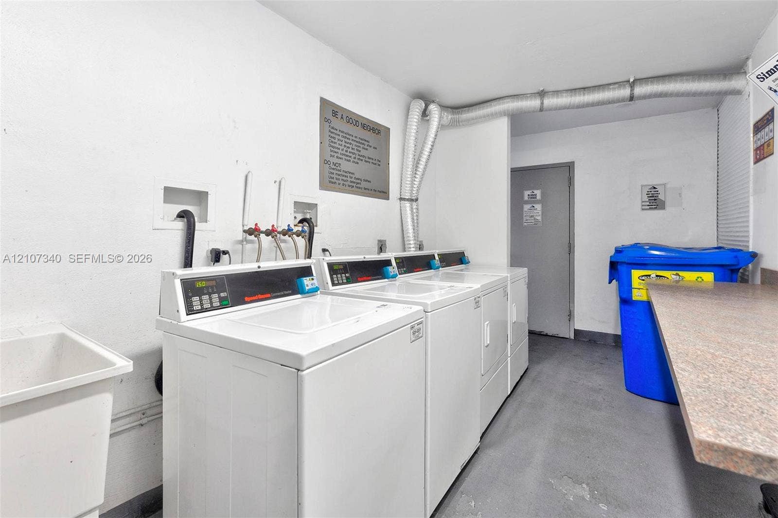 3401 N Country Club Drive, #406, Aventura, Aventura, FL 33180 Utility area featuring a deep basin utility sink, multiple laundry appliances, and a laminate-surface folding counter