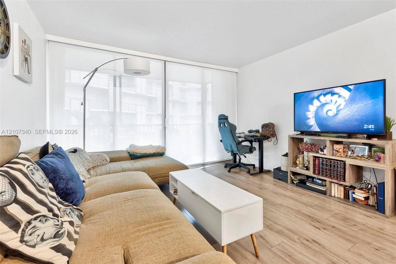 3401 N Country Club Drive, #406, Aventura, Aventura, FL 33180 Living area featuring wood-finish flooring and expansive floor-to-ceiling sliding glass doors with roller shades