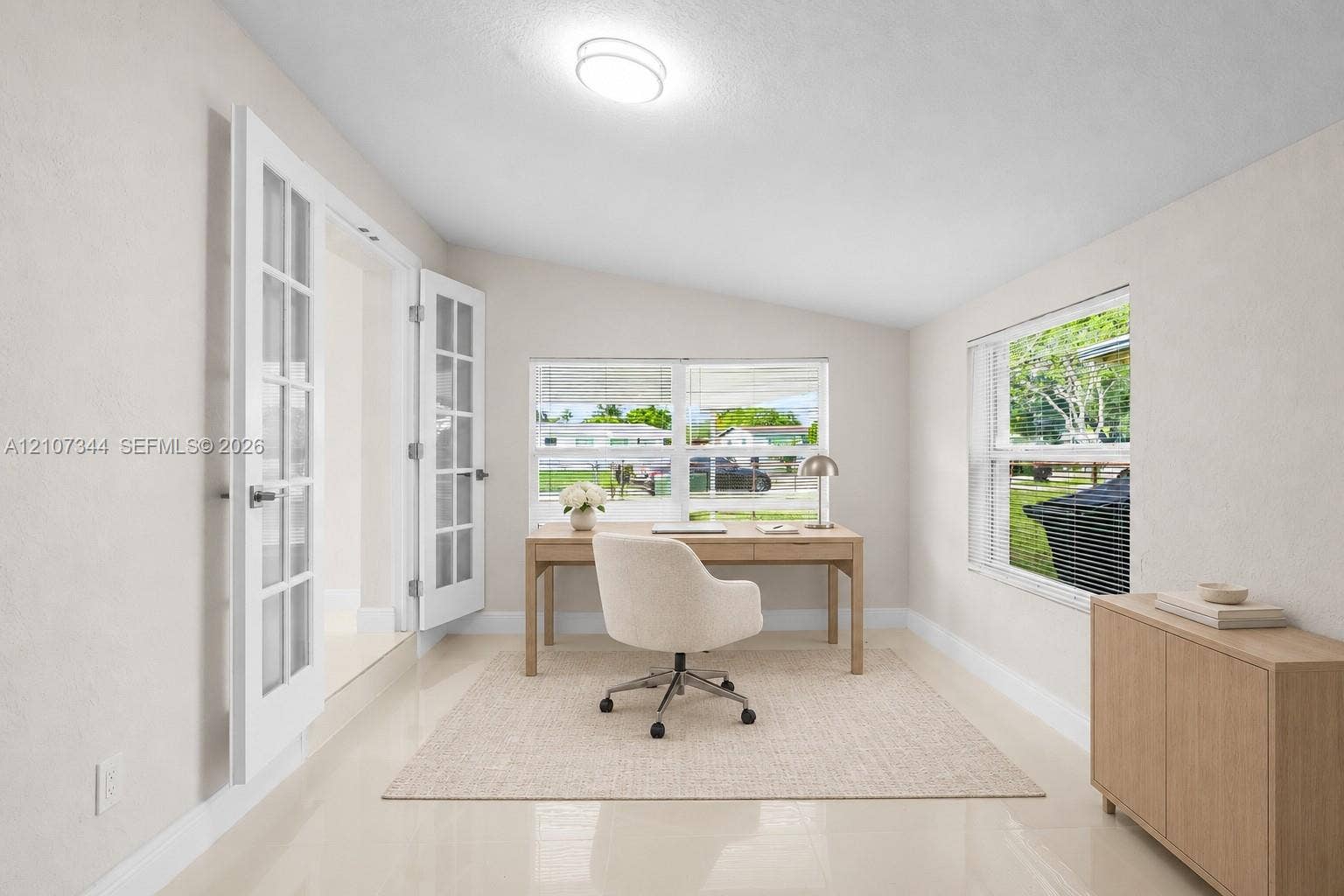 Room featuring neutral wall tones, polished tile flooring, double French doors, and dual-pane windows