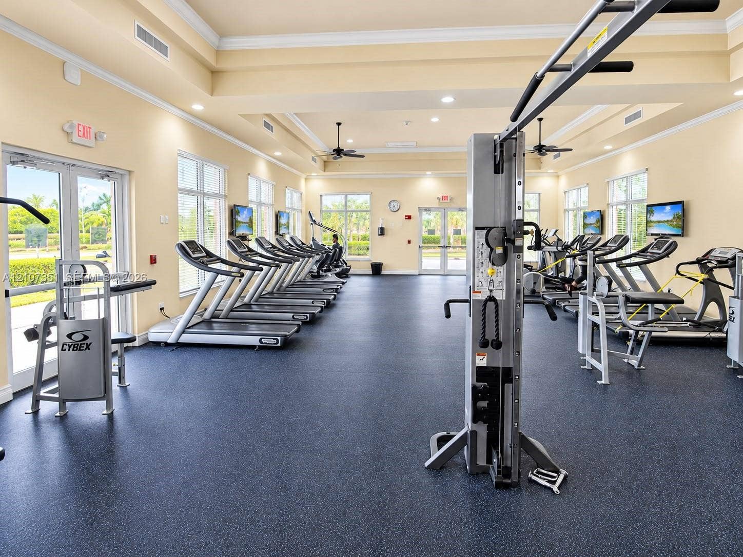 230 SE 29th Avenue, #1, Homestead, Homestead, FL 33033 Fitness center featuring rubberized flooring, recessed tray ceilings, multiple glass-paned double doors, and expansive windows
