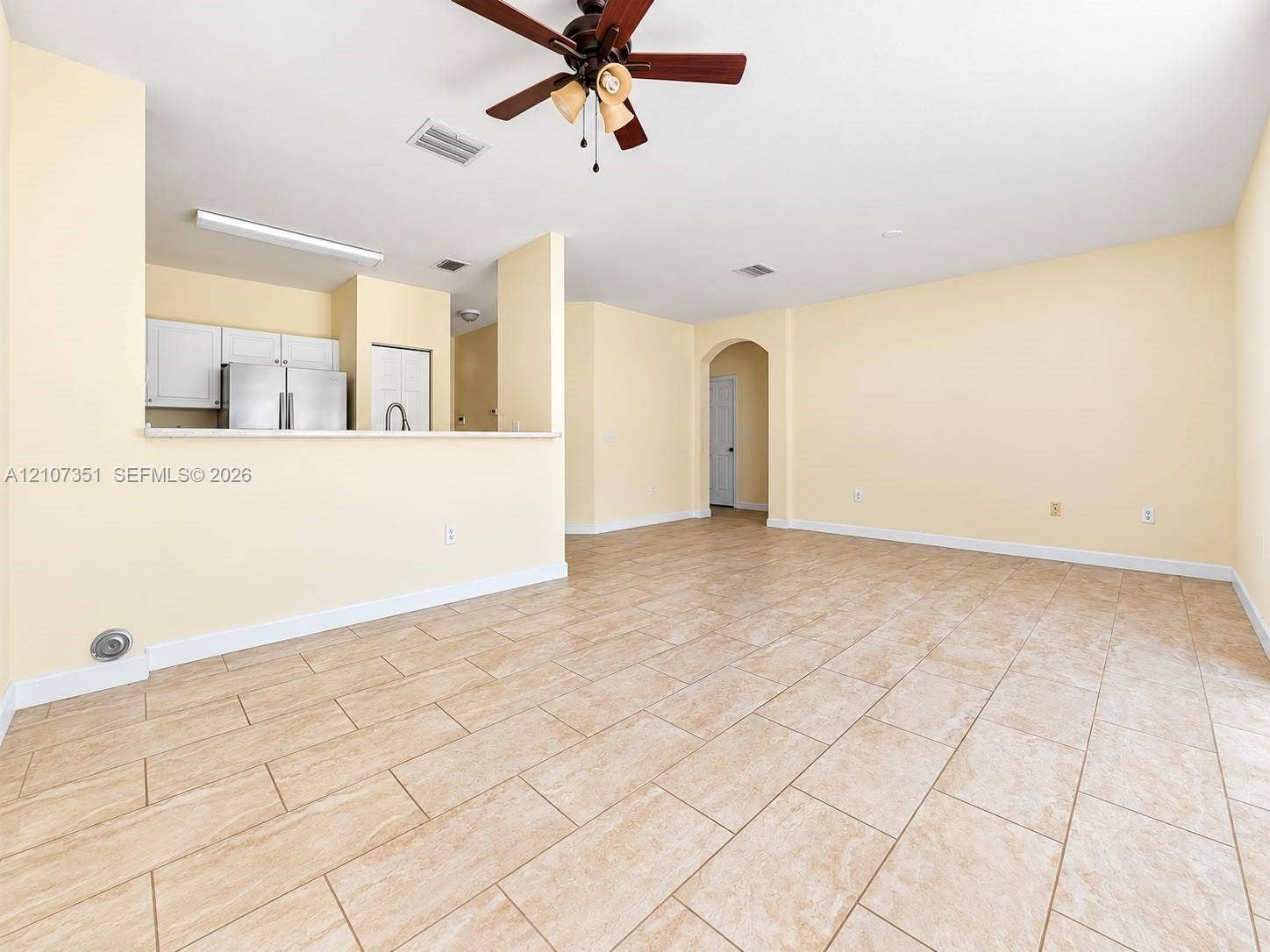 230 SE 29th Avenue, #1, Homestead, Homestead, FL 33033 Open interior featuring ceramic tile flooring, a multi-blade ceiling fan with integrated lighting, and a breakfast bar overlooking white cabinetry