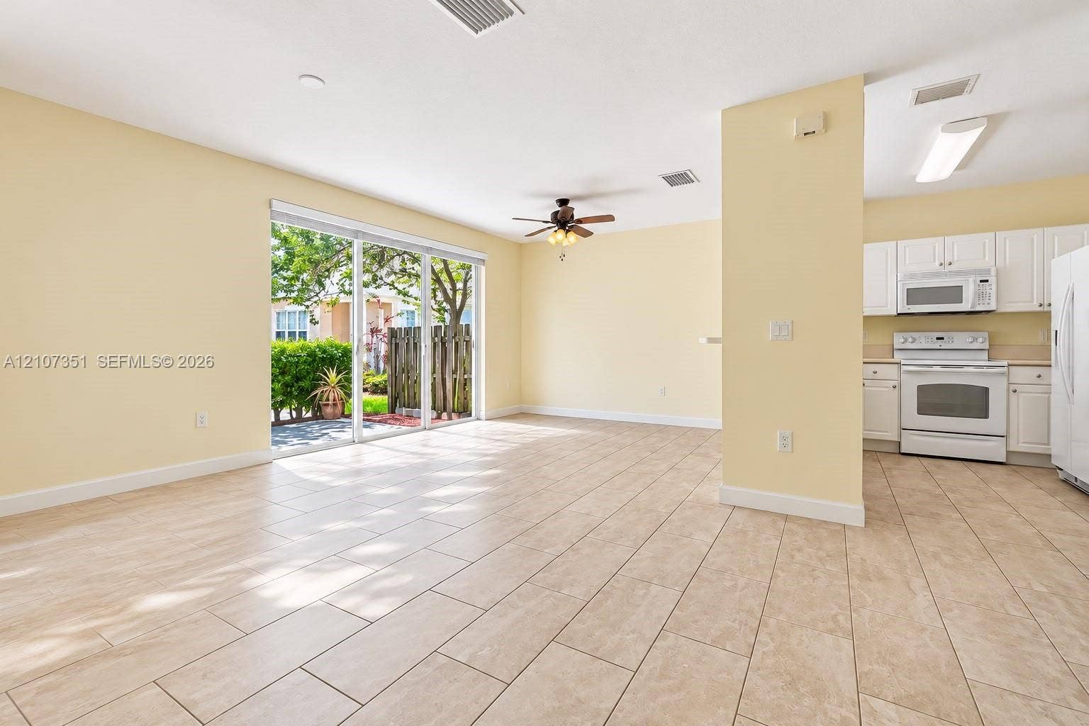 230 SE 29th Avenue, #1, Homestead, Homestead, FL 33033 Neutral tile flooring, sliding glass door, ceiling fan, white kitchen cabinetry, and integrated white appliances