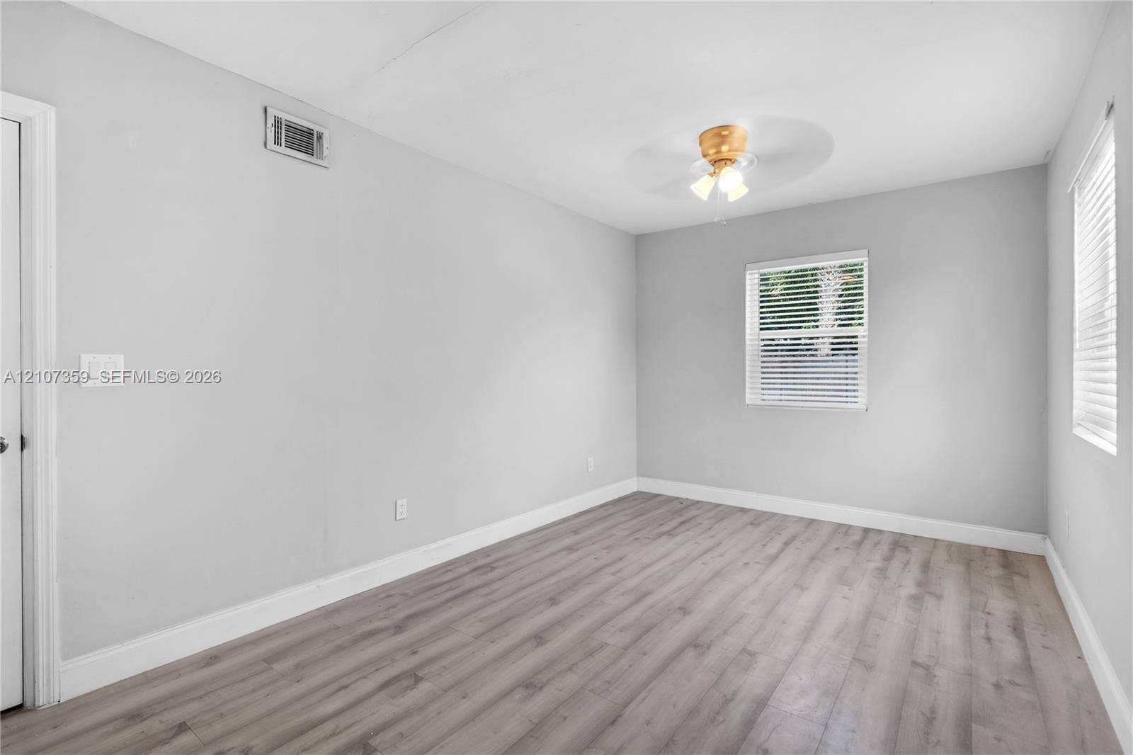 4500 NE 18th Avenue, Pompano Beach, Pompano Beach, FL 33064 Neutral-toned walls, ceiling-mounted light fixture, and windows featuring horizontal blinds
